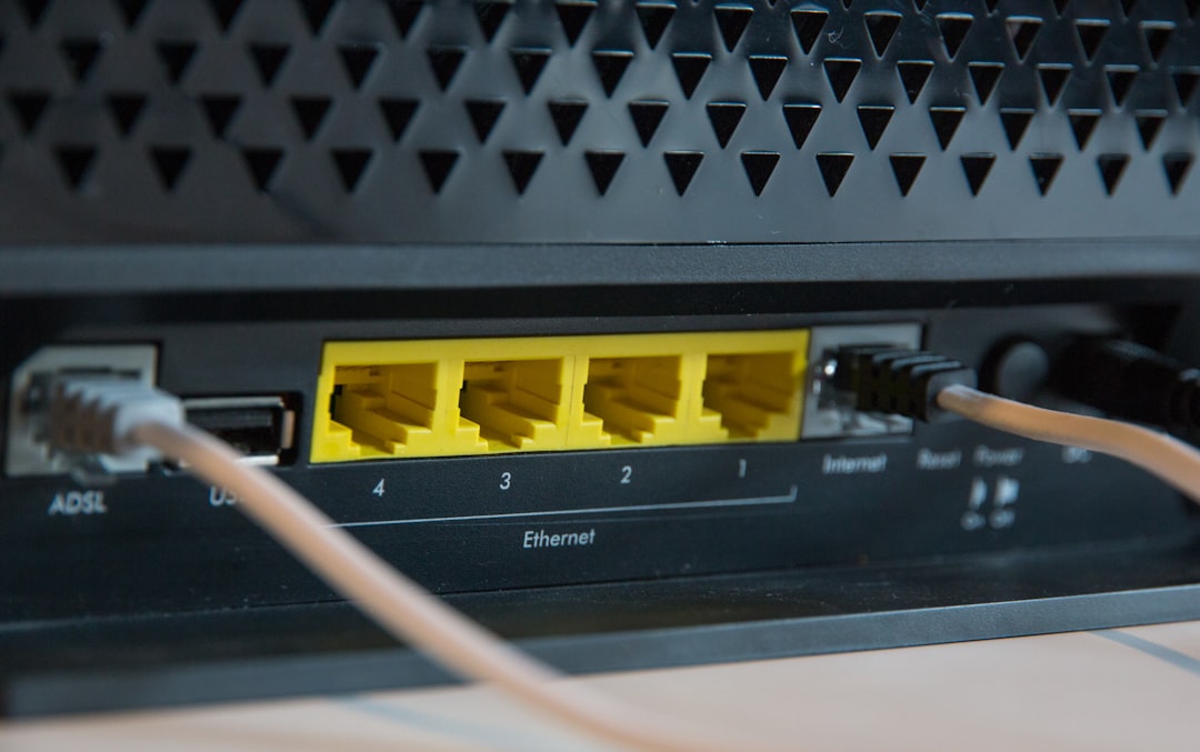 Back of a network router showing four yellow Ethernet ports labeled 1–4 with cables plugged in; USB/ADSL port on the left.