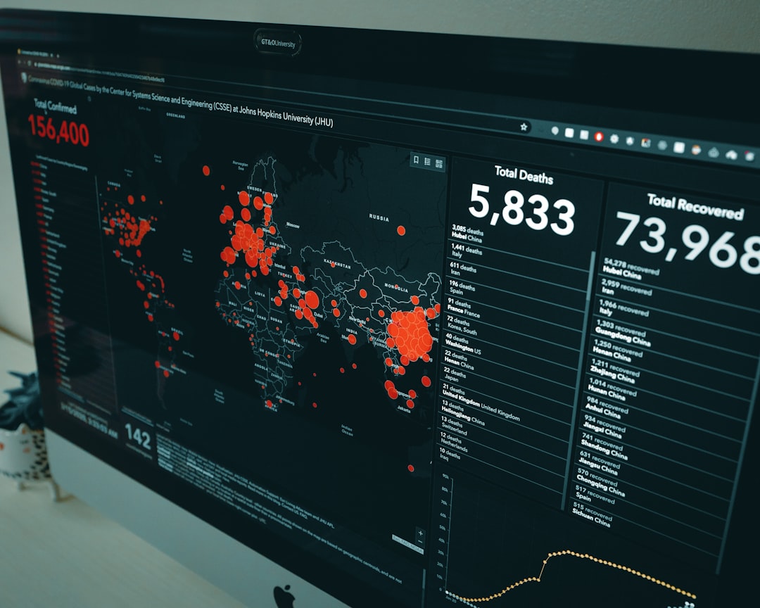 Data dashboard showing a world map with red data points and panels for totals, deaths, and recovered (dark UI).