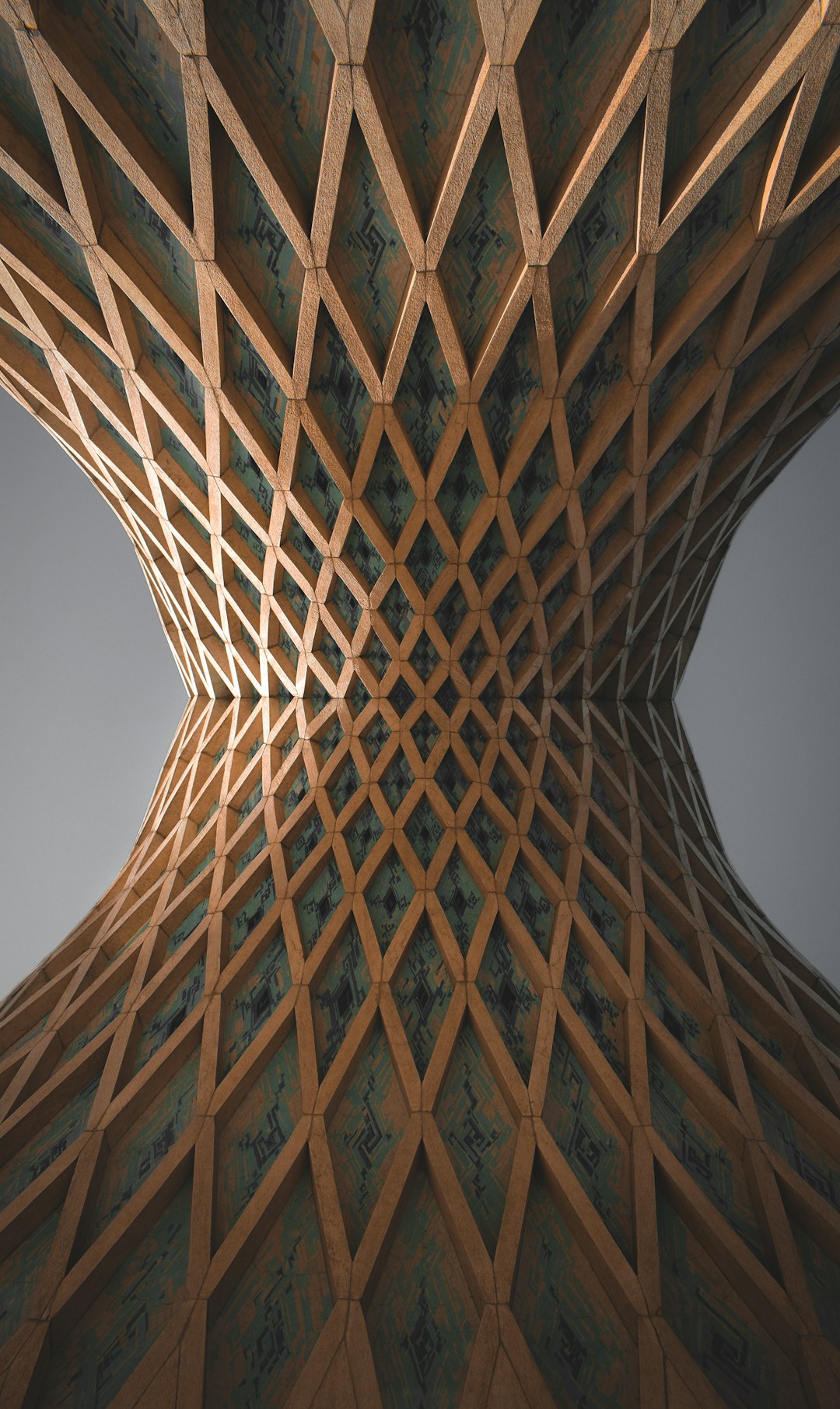 Undulating wooden lattice facade with diamond panels forming an hourglass shape, viewed from below.
