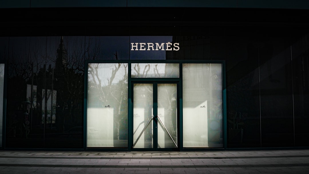 Hermès storefront with a glass entrance and frosted side panels, branding visible above the doors.