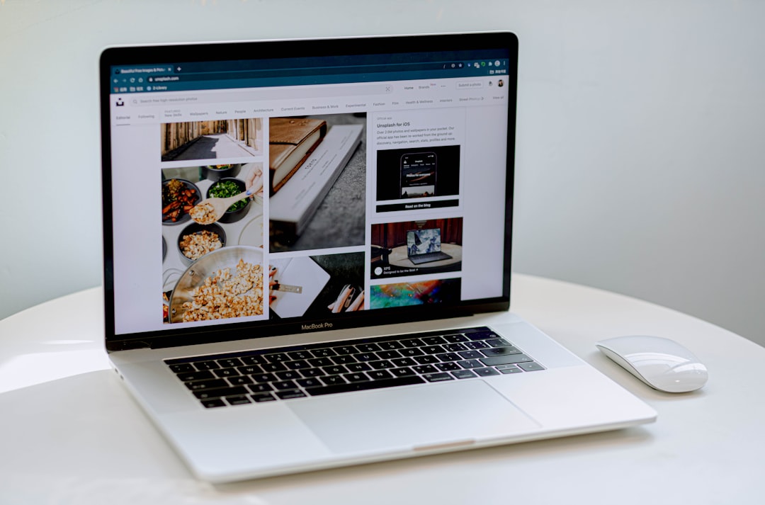 MacBook Pro on a white table displaying a photo collage, including bowls of cereal and books on screen, with a white mouse nearbyl.