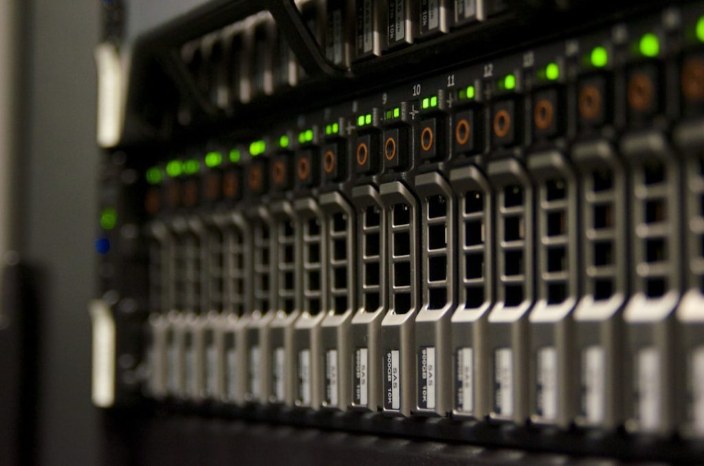 Server rack with multiple hot-swappable drive bays and green indicator lights, typical data center hardware understood as storage array.