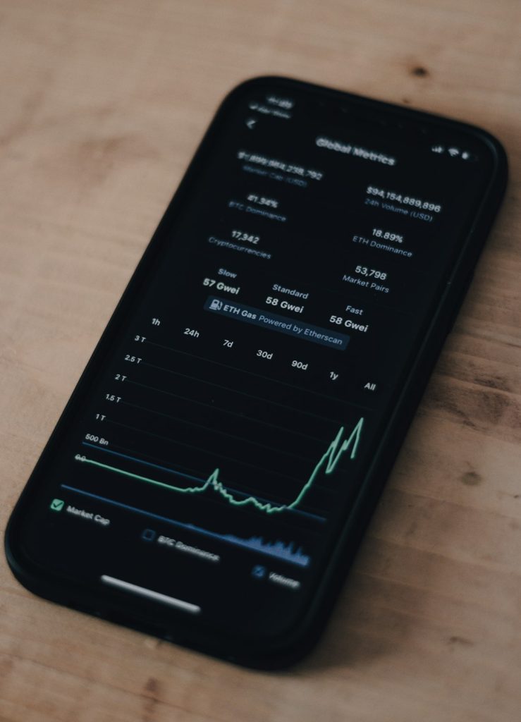 Smartphone screen showing a cryptocurrency market dashboard with a rising line chart and numeric stats on a dark UI.