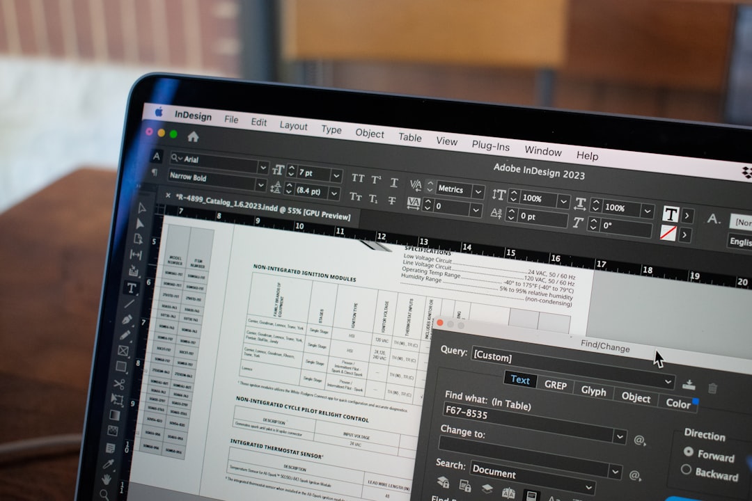 Open laptop displaying Adobe InDesign with a technical document and layout tools, conveying a layout editor at work.