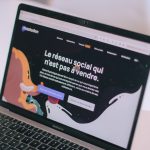 Laptop screen showing Mastodon homepage in French, with a dark background and large white headline amid colorful illustrations.