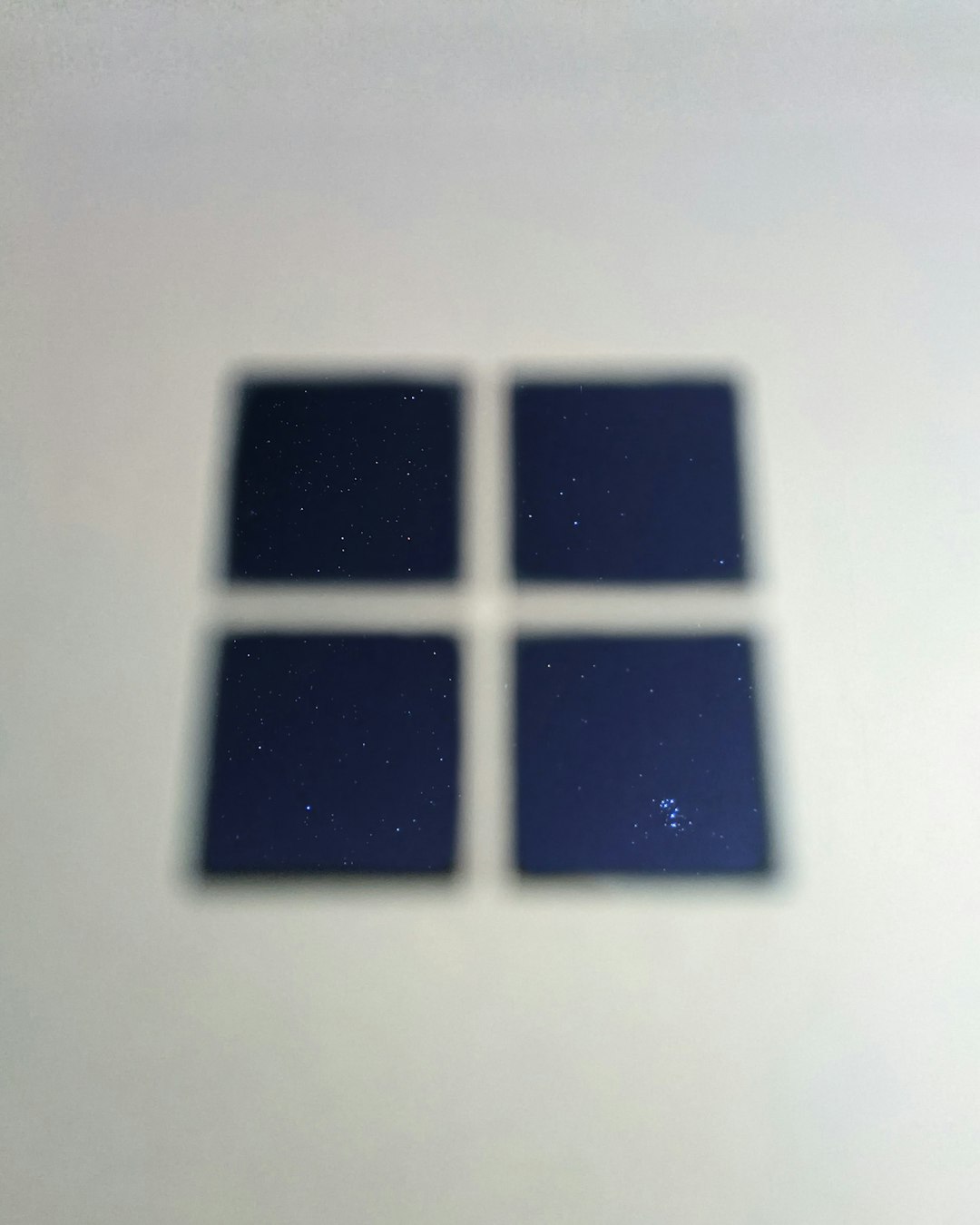 Blurred image of a 2x2 grid of dark blue squares, each with a starry night pattern on a white surface.