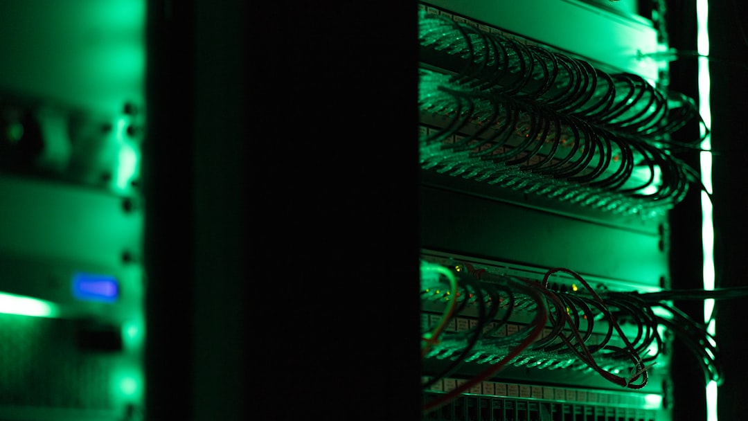 Server rack with neatly organized network cables in a dimly lit data center bathed in green light