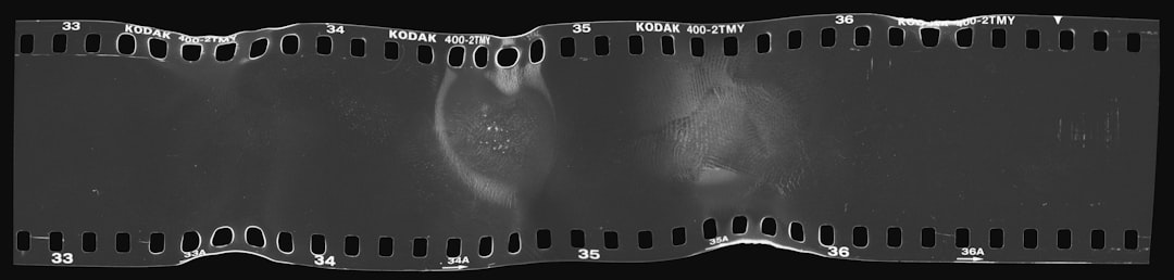 Film negative strip with perforated edges and a faint central image. Sprocket holes run along both sides with Kodak markings visible.