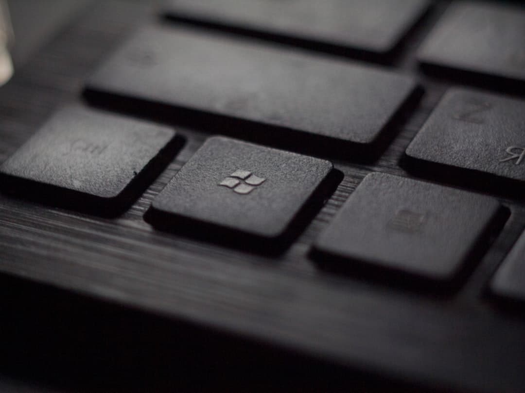 Close-up of a laptop keyboard with the Windows key in focus on a dark keycap