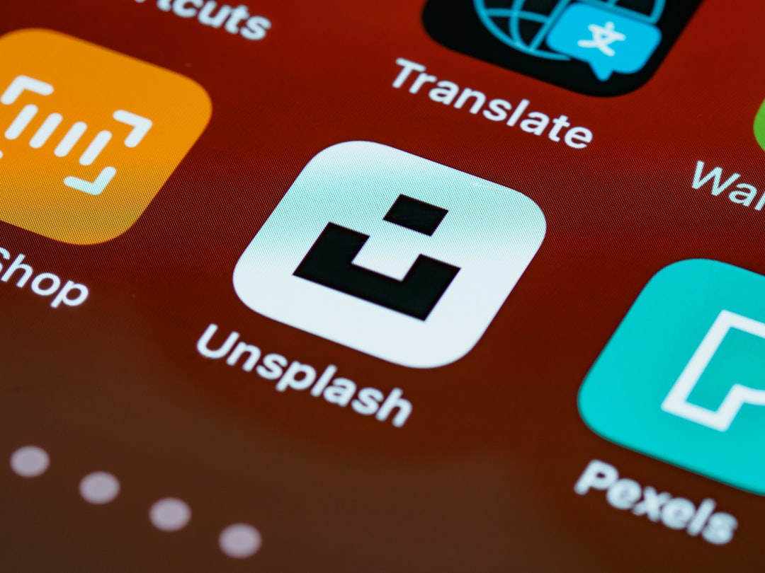 Close-up of a smartphone home screen showing the Unsplash app icon among other colorful apps.