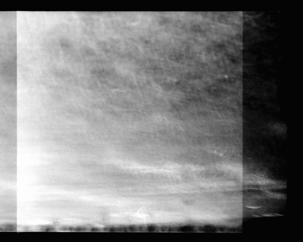Abstract grayscale texture with a bright vertical strip on the left and a dark edge on the right.