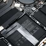 Inside view of a laptop with the bottom shell removed, showing the cooling fan, motherboard, and battery.