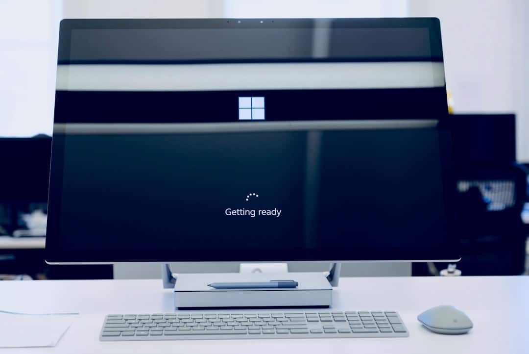 All-in-one Windows desktop on a white desk, monitor showing Windows logo and “Getting ready.”