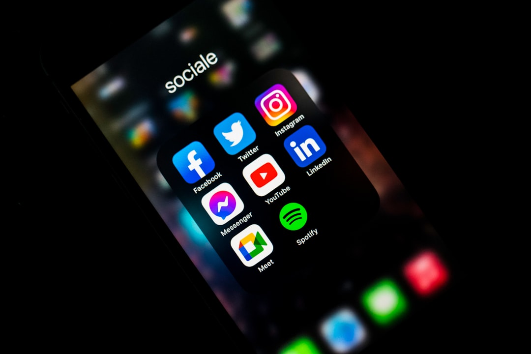 Phone screen displaying social media apps: Facebook, Twitter, Instagram, LinkedIn, YouTube, Messenger, Meet, Spotify.