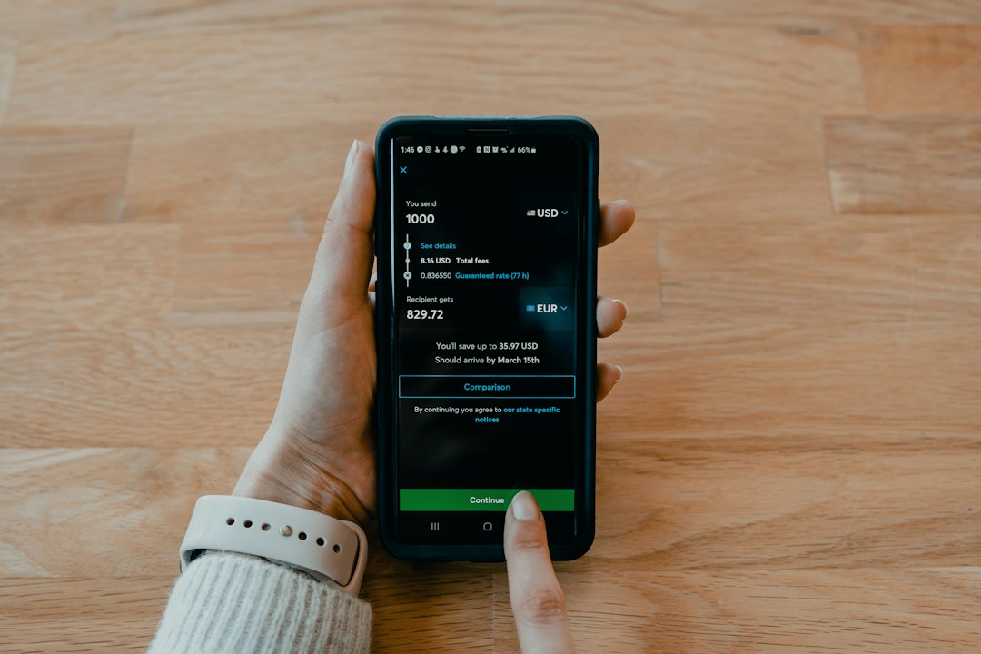 Hand holding a smartphone displaying a money transfer app with 1000 USD sent and 829.72 EUR to the recipient, and a green Continue button.