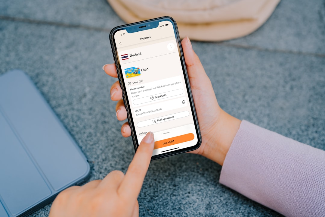 Close-up of a hand tapping a smartphone displaying a mobile app form to ship a package to Thailand, with Dtac image and an orange 'Use eSIM' button