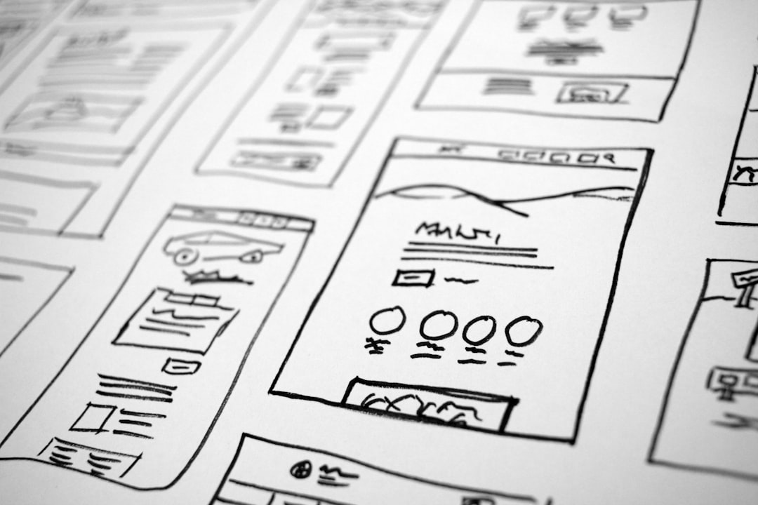 Hand-drawn UI wireframes on paper showing multiple app screens with icons and text blocks