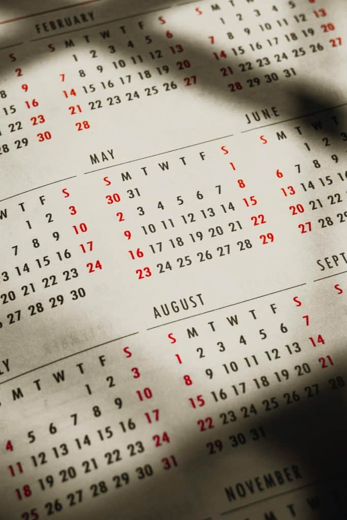 Close-up of a vintage desk calendar page showing May, June, August, and November with red weekend dates.