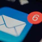 Close-up of a blue email app icon with a white envelope and a red notification badge showing 6 unread messages