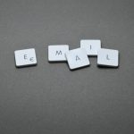 White square keyboard keys arranged to spell the word EMAIL on a gray surface.