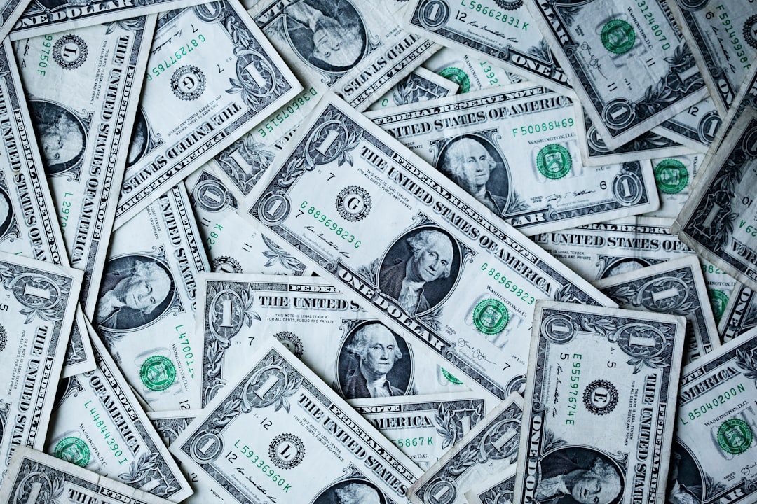 Pile of overlapping U.S. one-dollar bills scattered across the surface.