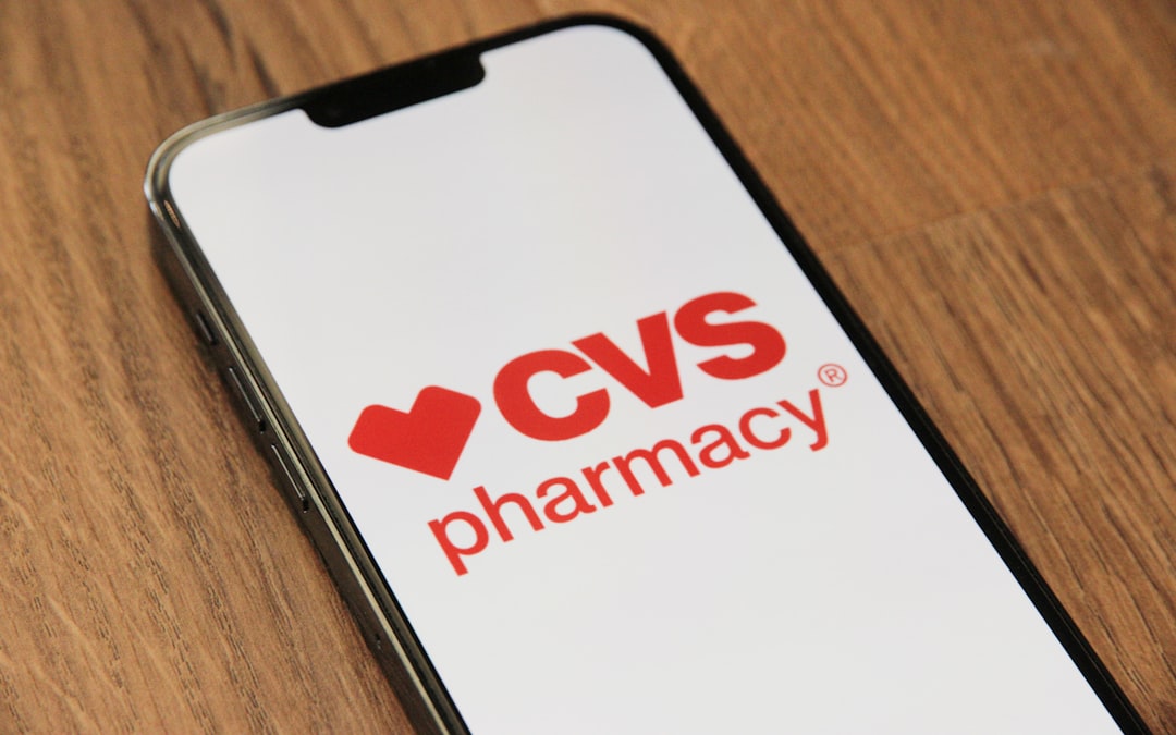 CVS Pharmacy logo displayed on a smartphone screen placed on a wooden table