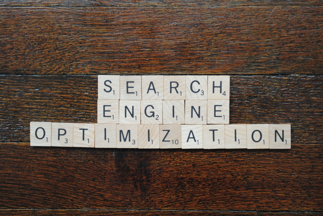 Wooden Scrabble tiles spell 'SEARCH ENGINE OPTIMIZATION' on a dark wood surface.