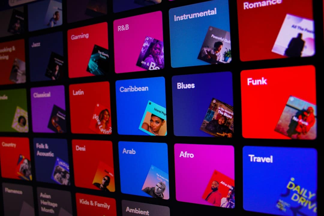 Grid of colorful square tiles labeled with music genres (e.g., Blues, Funk, Afro) and sample album art thumbnails in a catalog-style interface.