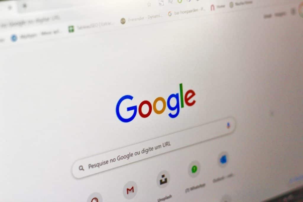 Google homepage shown on a computer screen with a colorful logo and search bar central to the page.