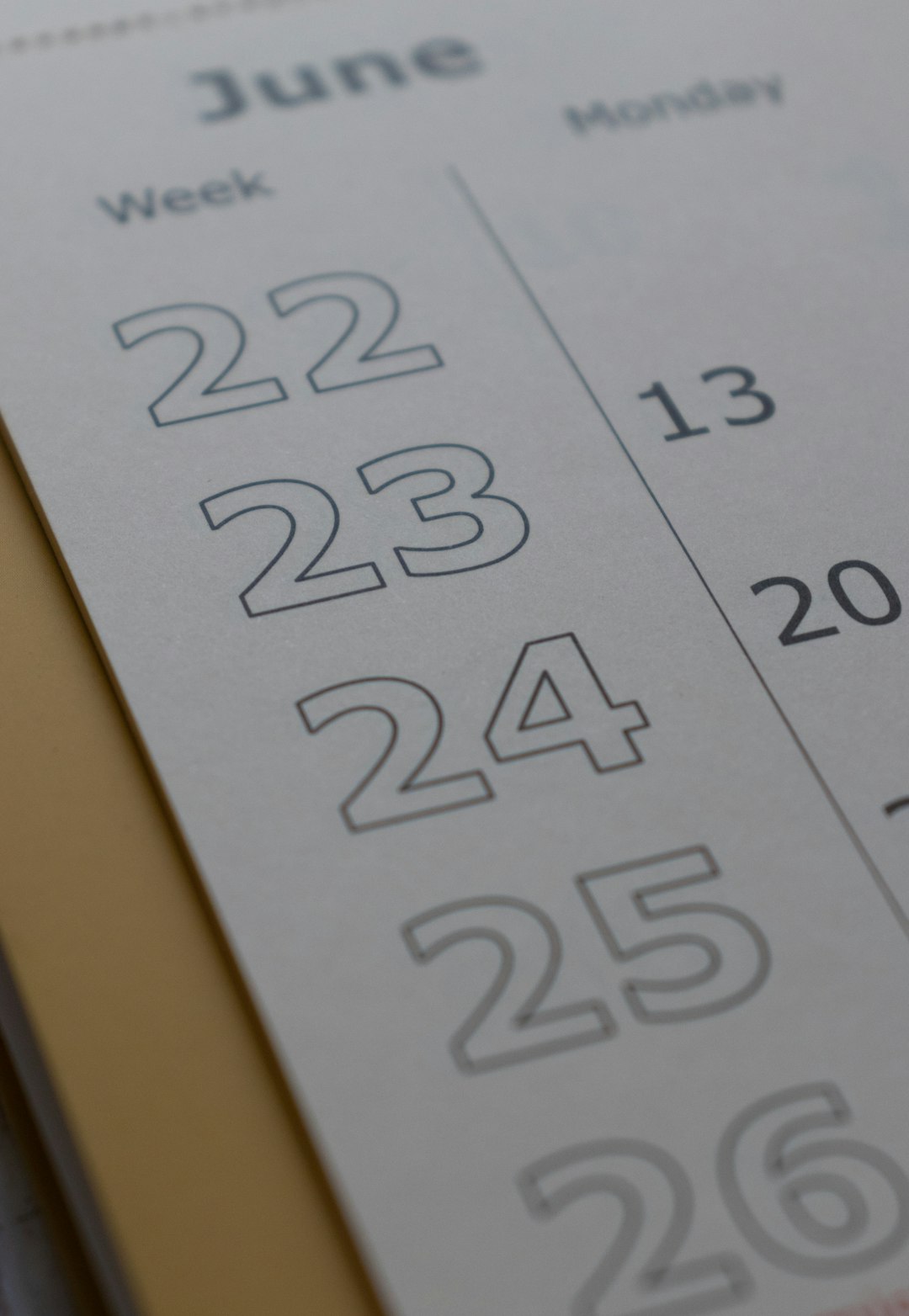 Close-up of a calendar page showing June with dates 22, 23, 24, and 25 visible.