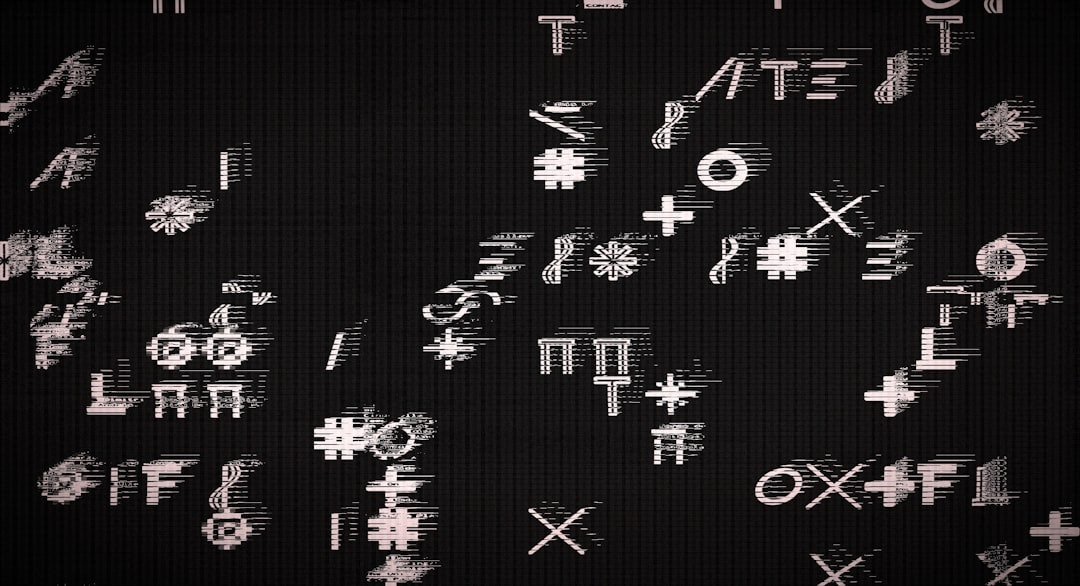 Abstract glitch-art: scattered white symbols and letters on a dark, textured background.