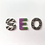 Word 'SEO' formed by decorative patterned letters on a white background (S with black/white geometric pattern, E with purple/green abstract design, O with black/white shapes).