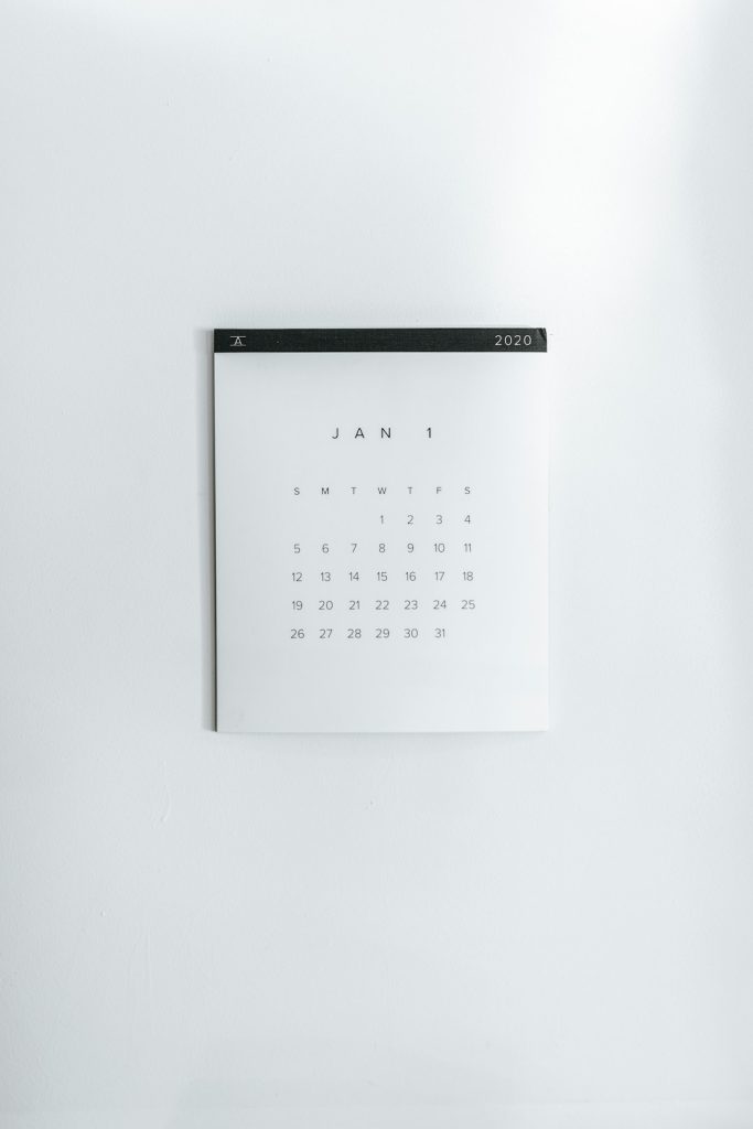 Minimalist white calendar on a wall, showing January 1, 2020 with a grid of days beneath the month.