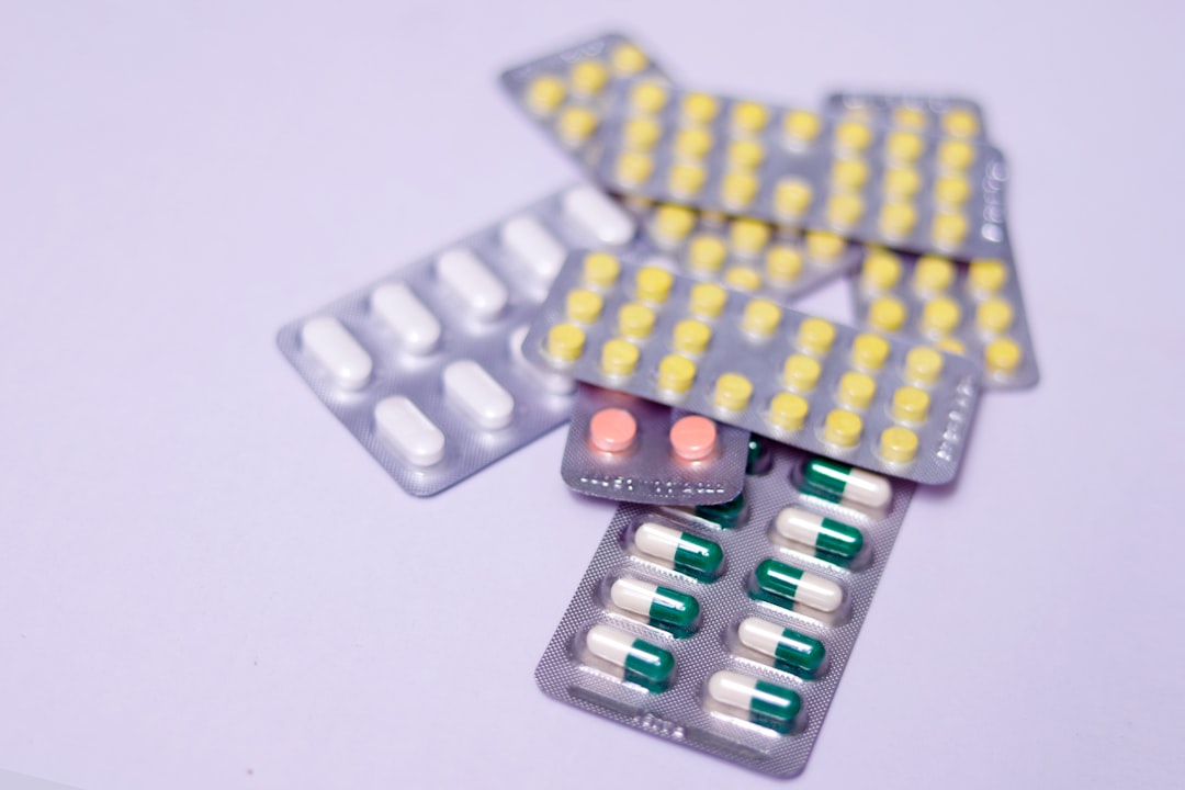 Assorted blister packs of pills and capsules on a light surface.