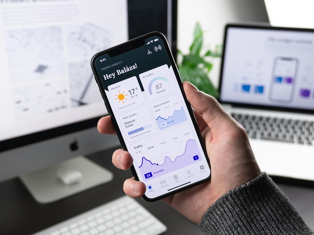 Phone shows a dashboard app with weather, air quality, water quality, and traffic charts on a modern desk.
