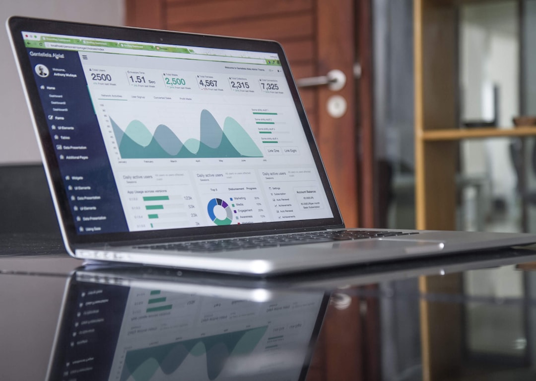 Laptop on a desk displaying a data analytics dashboard with charts and graphs.