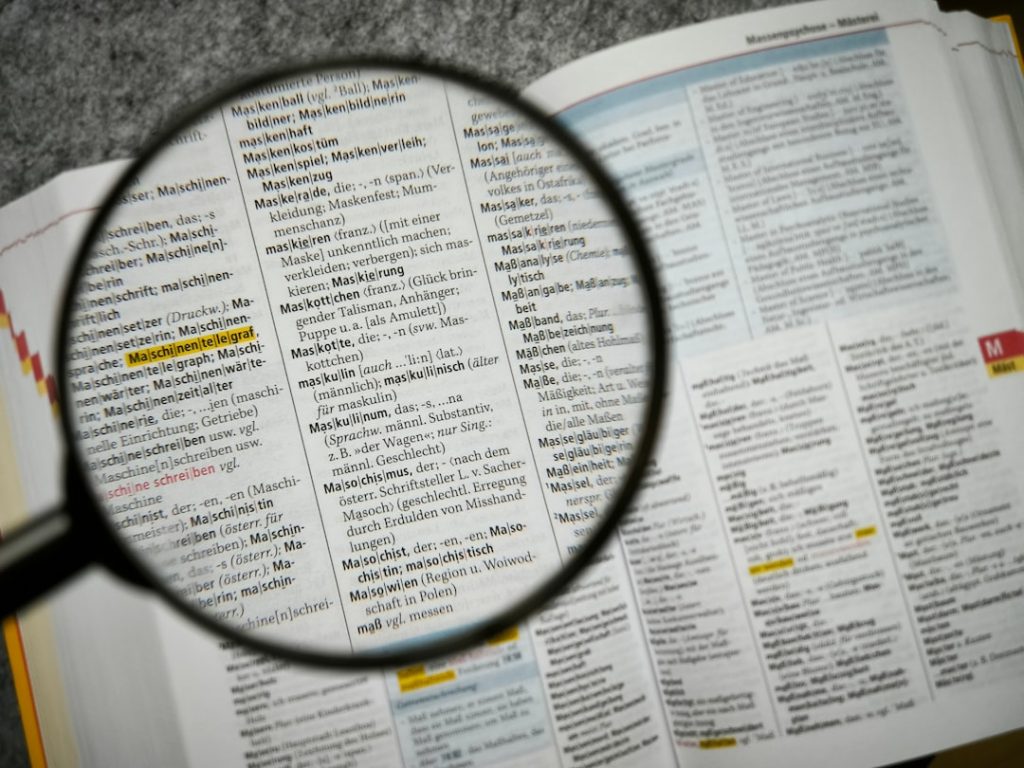 Magnifying glass over an open German dictionary, highlighting the entry for 'Maschine'.