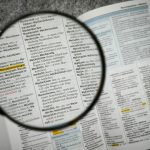 Magnifying glass over an open German dictionary, highlighting the entry for 'Maschine'.