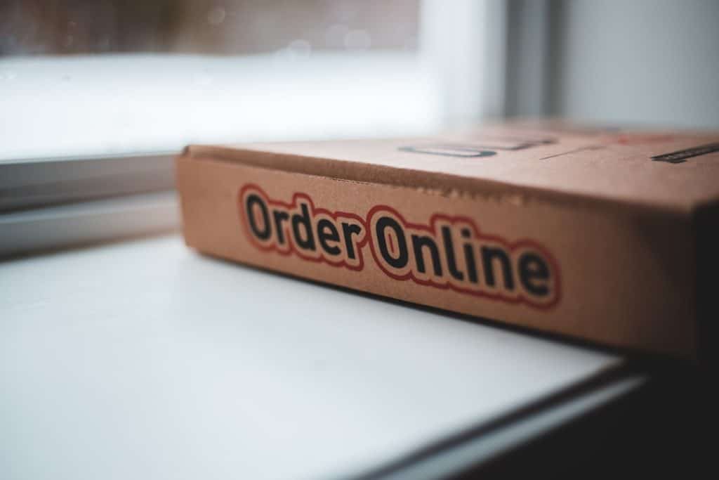 Cardboard delivery box on a windowsill with 'Order Online' branding visible