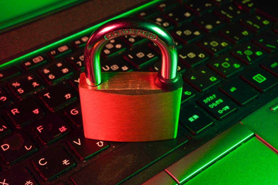 Padlock on a laptop keyboard bathed in red and green neon light, symbolizing cybersecurity.