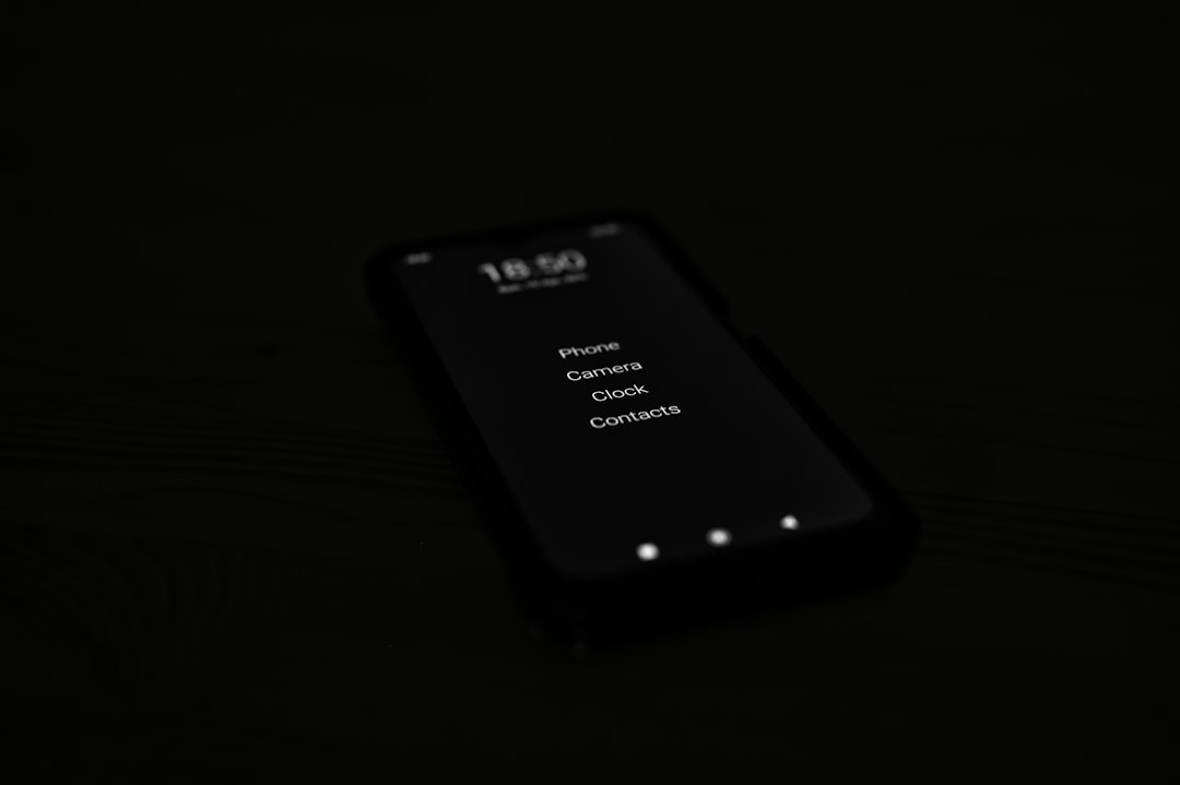 A dark smartphone screen showing a vertical list: Phone, Camera, Clock, Contacts.