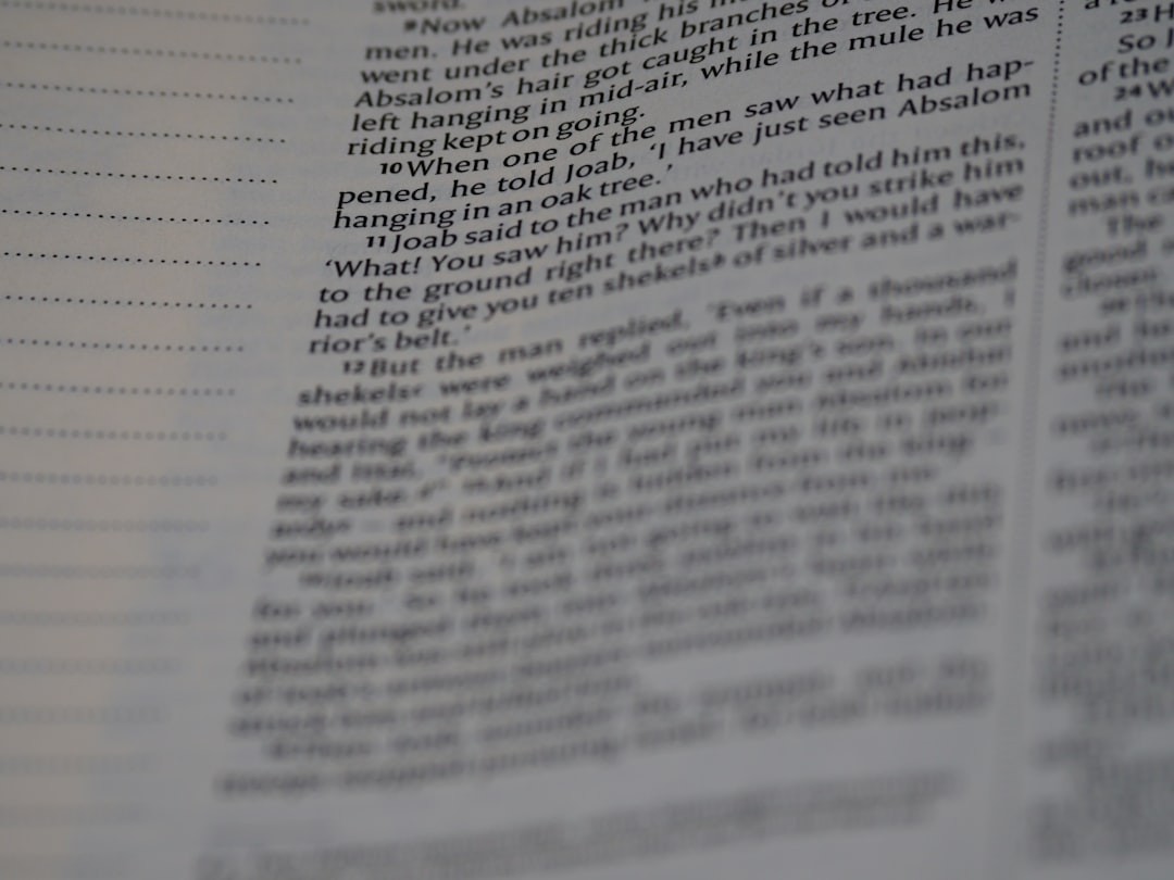 Close-up of a newspaper page with narrow columns of small black text on white paper; the text is slightly blurred.