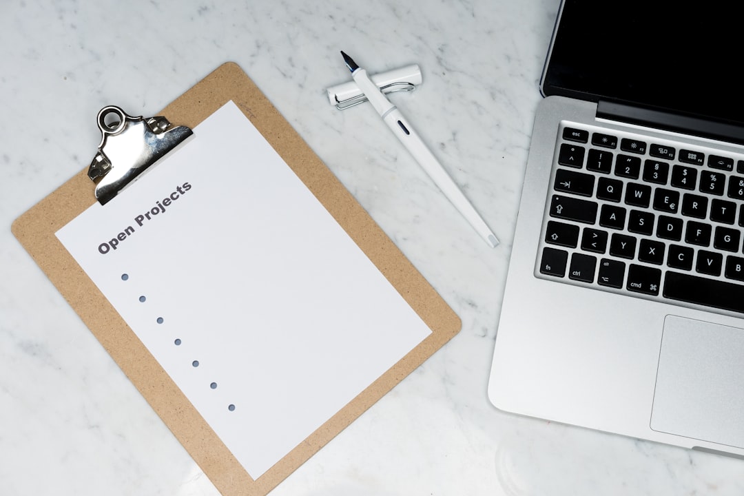 Clipboard with a sheet titled 'Open Projects' on a marble desk, beside a white pen and a laptop keyboard area.