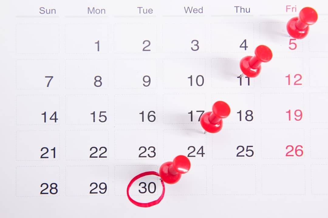 Monthly calendar with red pins marking events on the 5th, 11th, 17th, and a circled 30th. Fridays appear in red text.