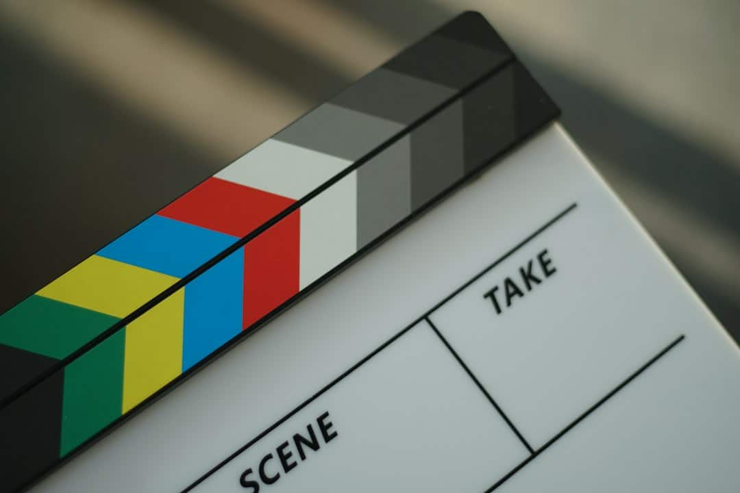 Close-up of a film clapperboard with multicolor color bars and the words SCENE and TAKE visible.