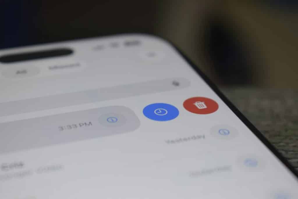 Close-up of a smartphone screen displaying a control panel with a blue timer button and a red delete button.
