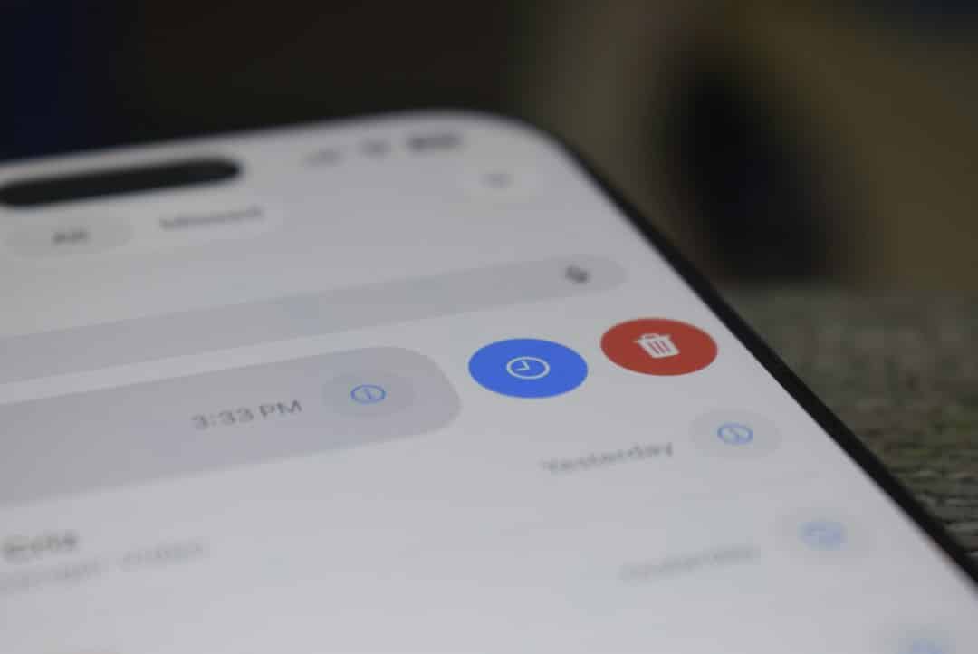 Close-up of a smartphone screen displaying a control panel with a blue timer button and a red delete button.
