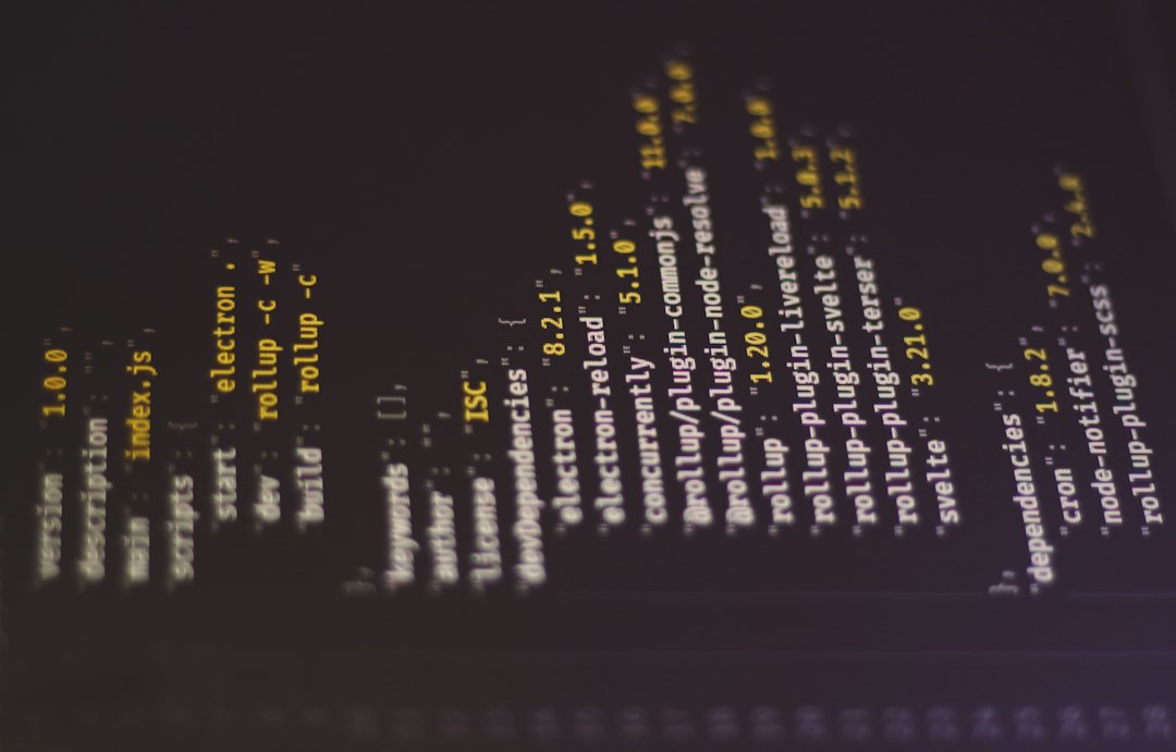 Close-up of a dark screen with vertical lines of yellow text resembling code, rotated 90 degrees counterclockwise.