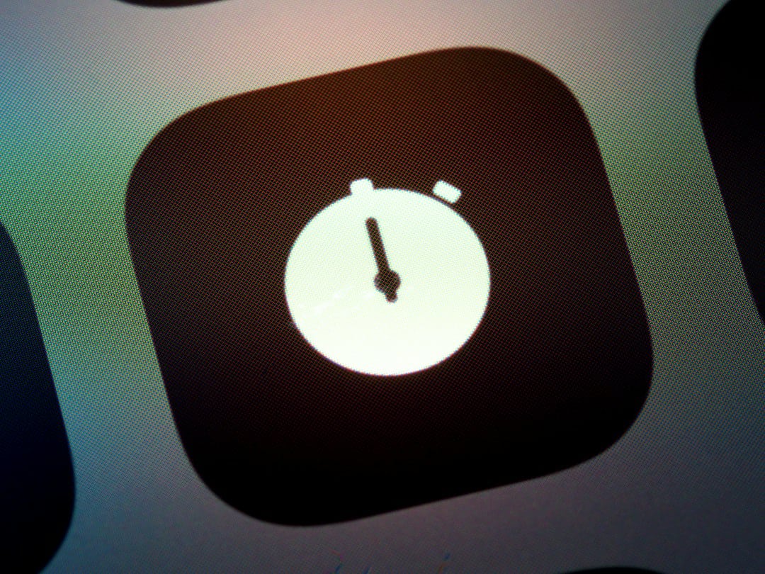 App icon showing a white stopwatch on a dark rounded-square background, representing the Clock/Timer function