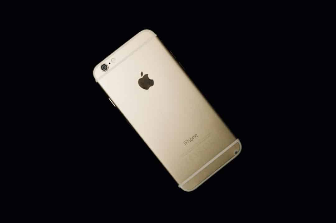 Gold iPhone back side shown against a black background, Apple logo visible.